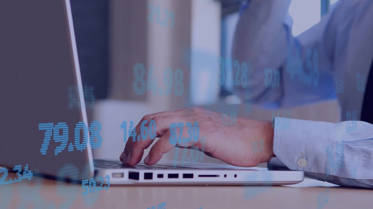 Mature man typing on laptop beside window, blue stock numbers animating to support finance analysis