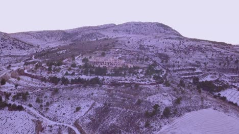 drone panning left in the mountains in spain with snow and a hotel