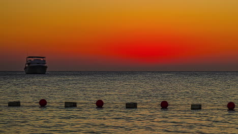 Zeitrafferaufnahme-Des-Sonnenuntergangs-Im-Hintergrund-über-Einer-Privaten-Yacht,-Die-Abends-In-Einer-Bucht-Anlegt