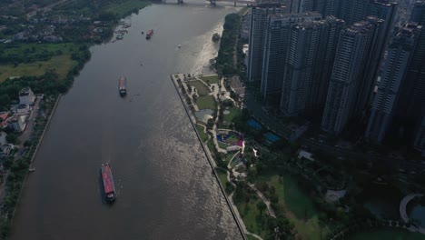 landmark and surrounding high rise buildings, saigon river with container boats