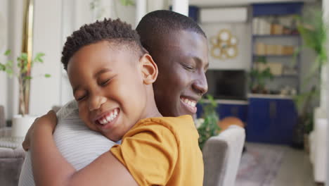 Video-of-happy-african-american-father-and-son-hugging-at-home