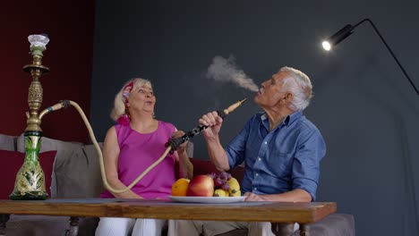 una pareja de ancianos disfrutando del narguile juntos.