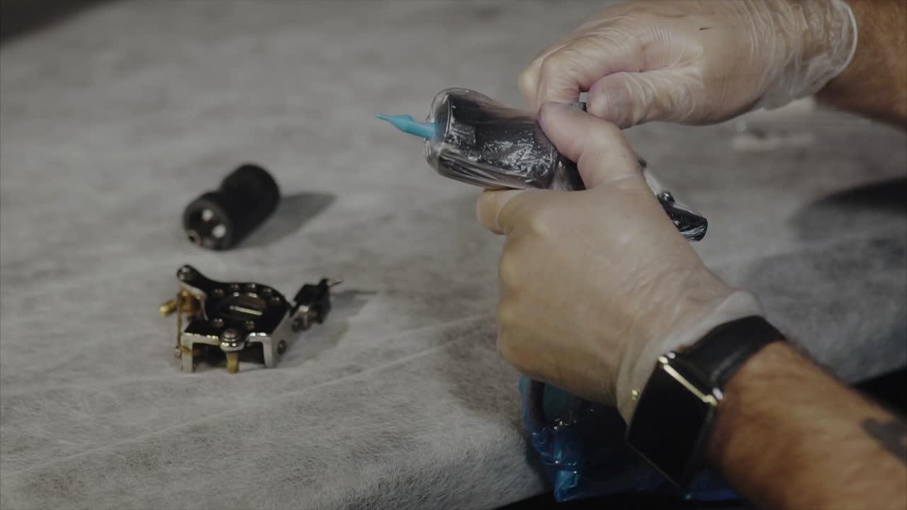 artista del tatuaje preparando la máquina de tatuaje