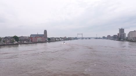 Aerial-View-Of-A-Motorboat-Cruising-Near-Dordrecht-Old-Town-In-South-Holland,-Netherlands