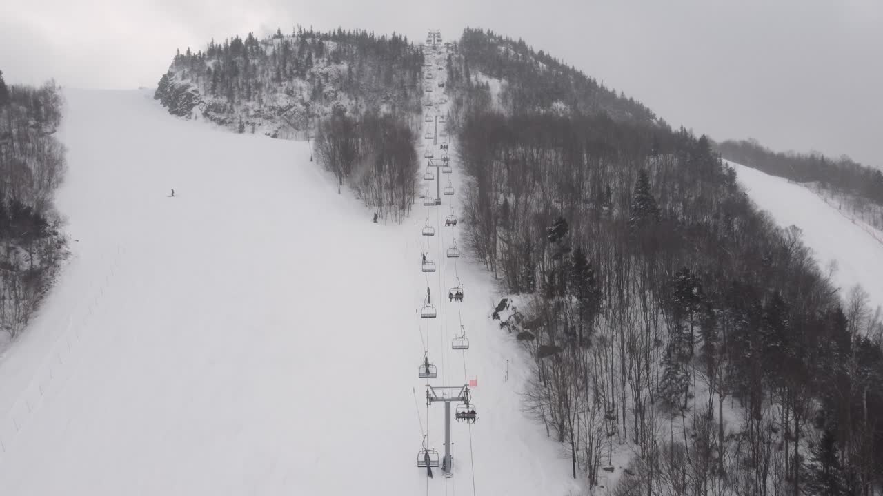 Snowy ski resort in Orford, Québec, featuring a ski lift and skiers on a winter slope