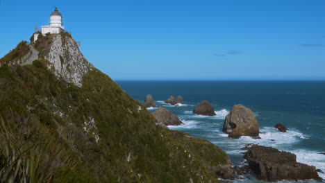 a stunning cliffside view in new zealand, with turquoise waters crashing against rocks