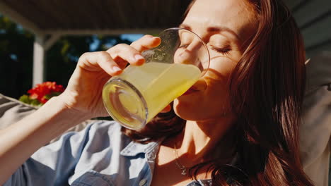 woman relaxing on porch swing, drinking juice