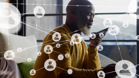 Animation-of-connected-icons-over-senior-african-american-man-talking-on-speaker-of-cellphone