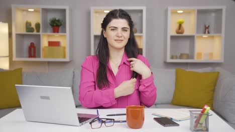 Home-office-worker-woman-looks-at-camera-with-happy-and-smiling-face.