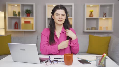 home office worker woman looks at camera with happy and smiling face.