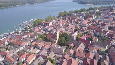 ascending establishing aerial shot of old zemun city centre with church and danube