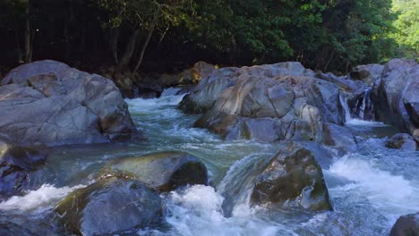 Primer-Plano-De-Agua-Que-Fluye-Entre-Rocas-Gigantes-Procedentes-De-Montañas-En-El-Desierto