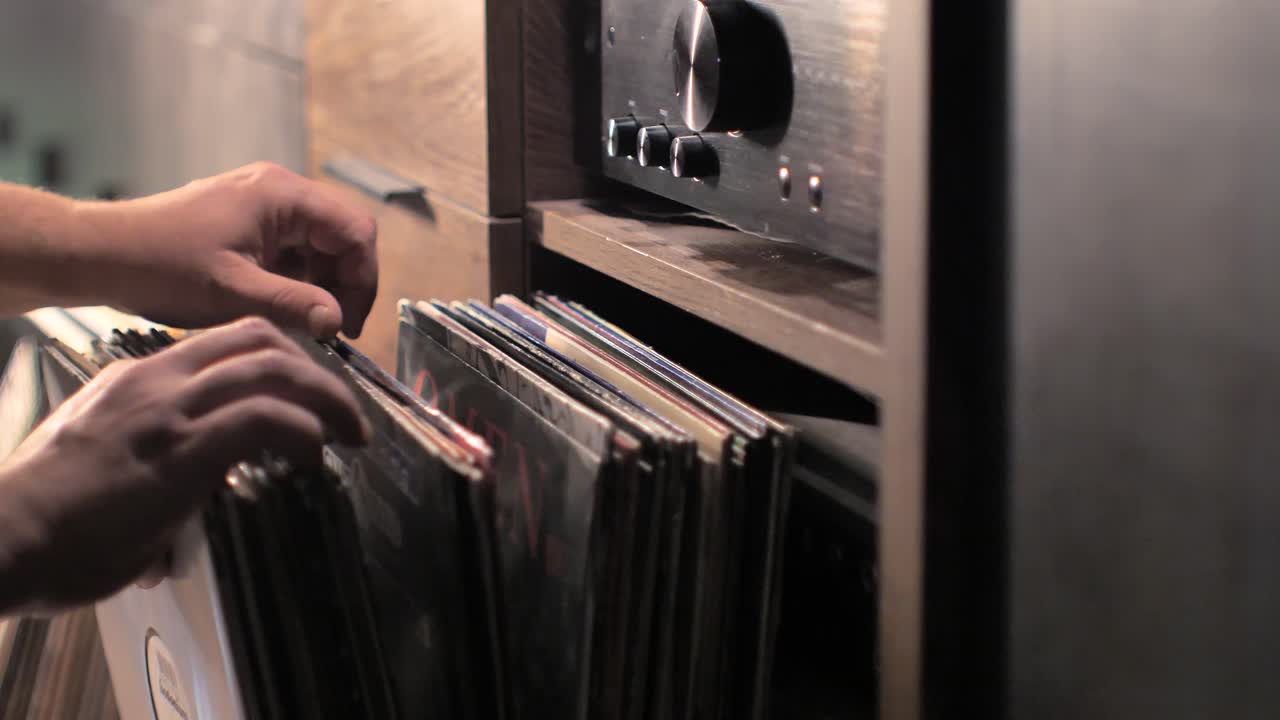 Close up man hands browsing vintage vinyl records at home. Searching music on a vinyl. Scene L