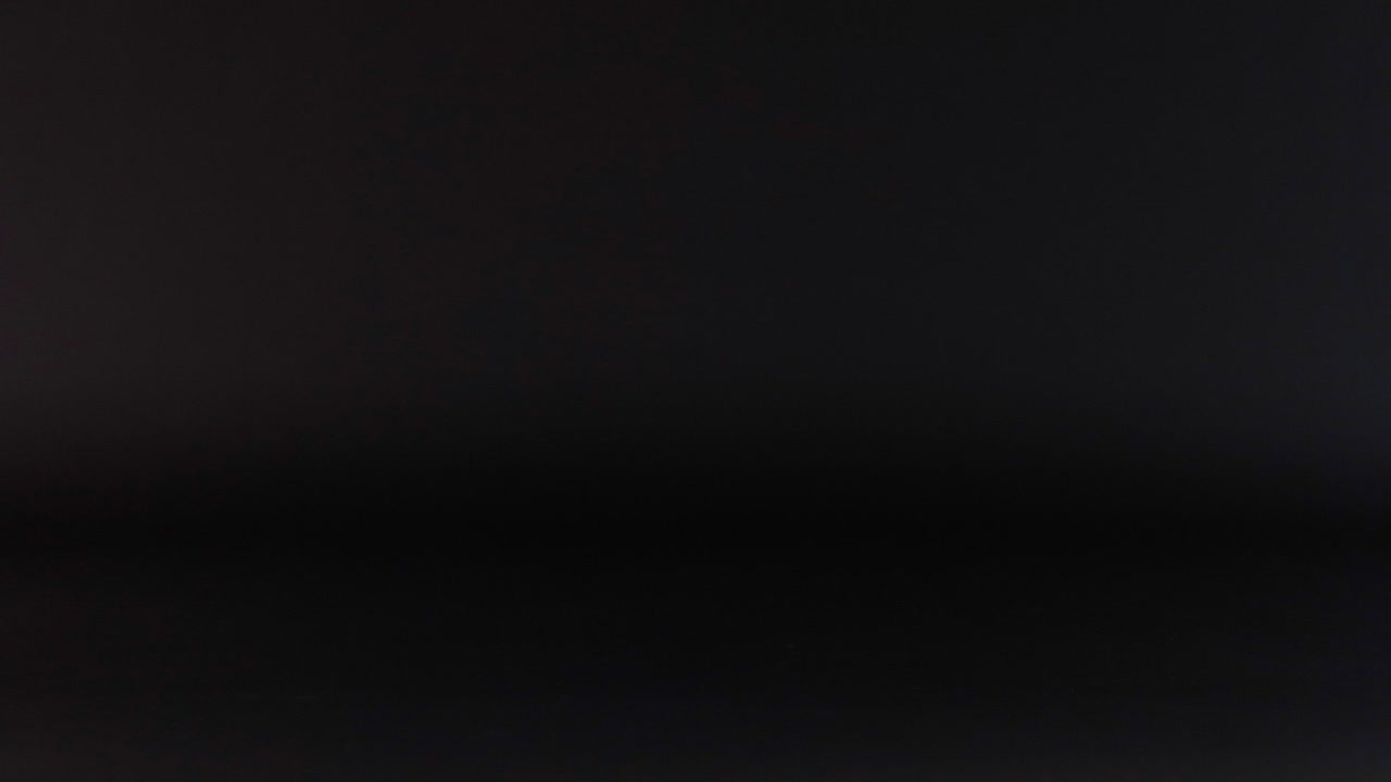 pelota de tenis azul rebotando contra un fondo oscuro