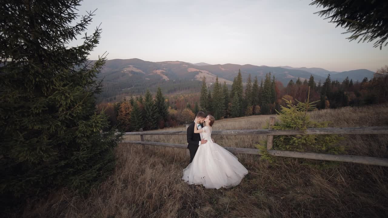 Novelli sposi. Sposo caucasico con sposa su un pendio di montagna. Coppia di sposi felici.