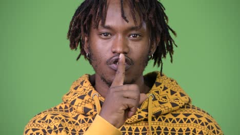 young handsome african man with finger on lips