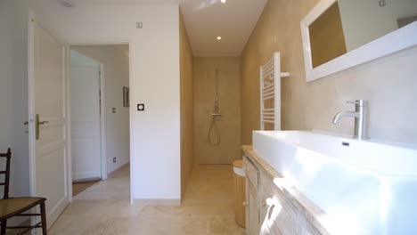 Slow-dolly-shot-revealing-a-modern-bathroom-with-shower-and-washbasin-in-a-villa