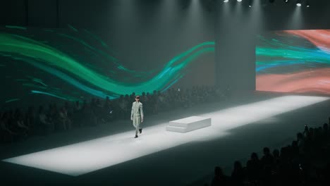 a stunning fashion runway show: a model showcases a striking outfit against a dynamic visual backdrop in a captivating presentation of style and creativity