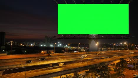 green screen of advertising billboard on expressway during the twilight with city background in bangkok, thailand.