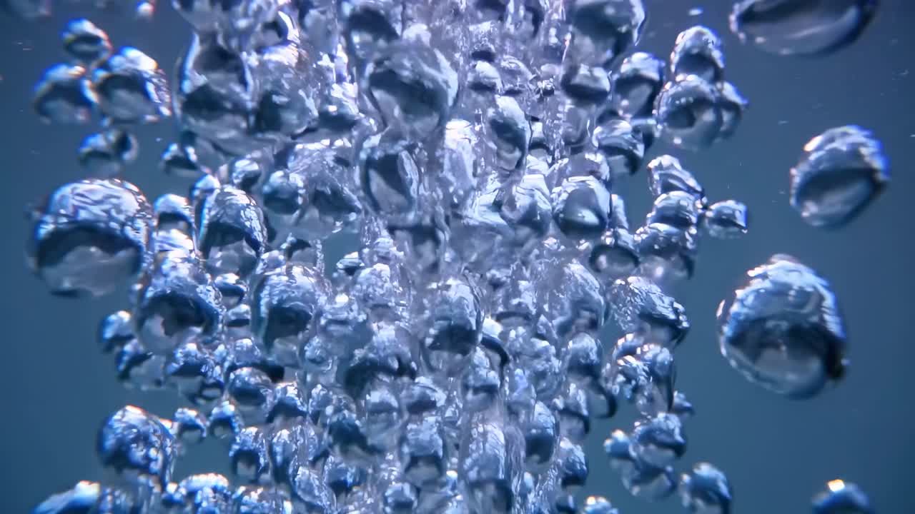 Un video subacqueo cattura le bolle che salgono su uno sfondo blu