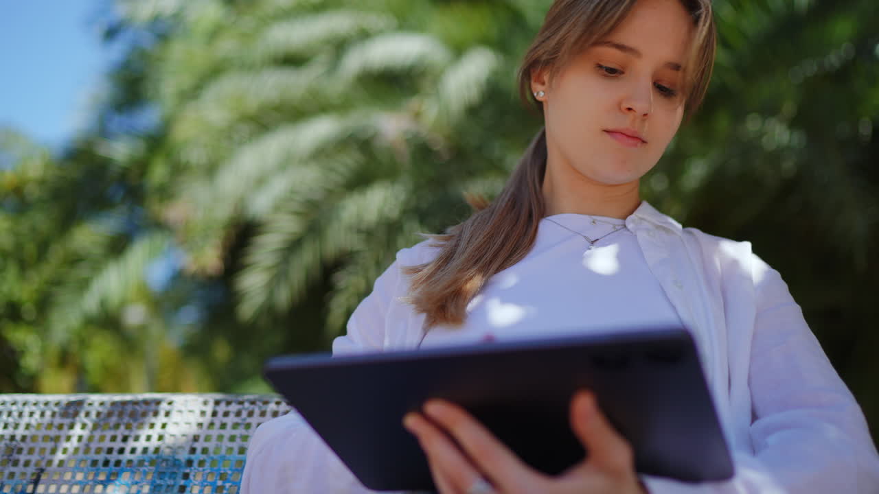Woman using a tablet in a park