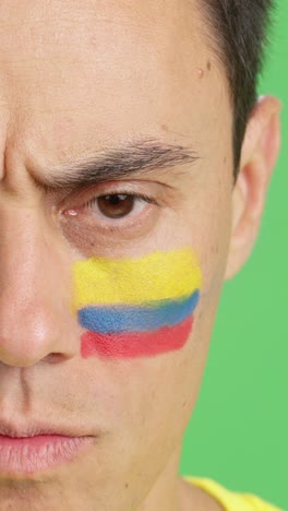 serious man with a colombian flag painted on the face