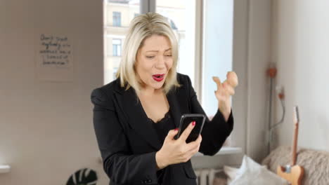 attractive blond business woman angry and updet as she loses money on a game app on her phone