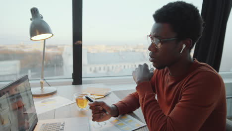 black businessman speaking with colleague on video call on laptop