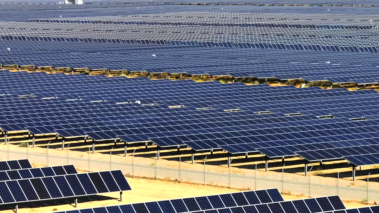 vista aérea ascendente que revela una granja solar que se extiende sin fin hacia el desierto de mojave