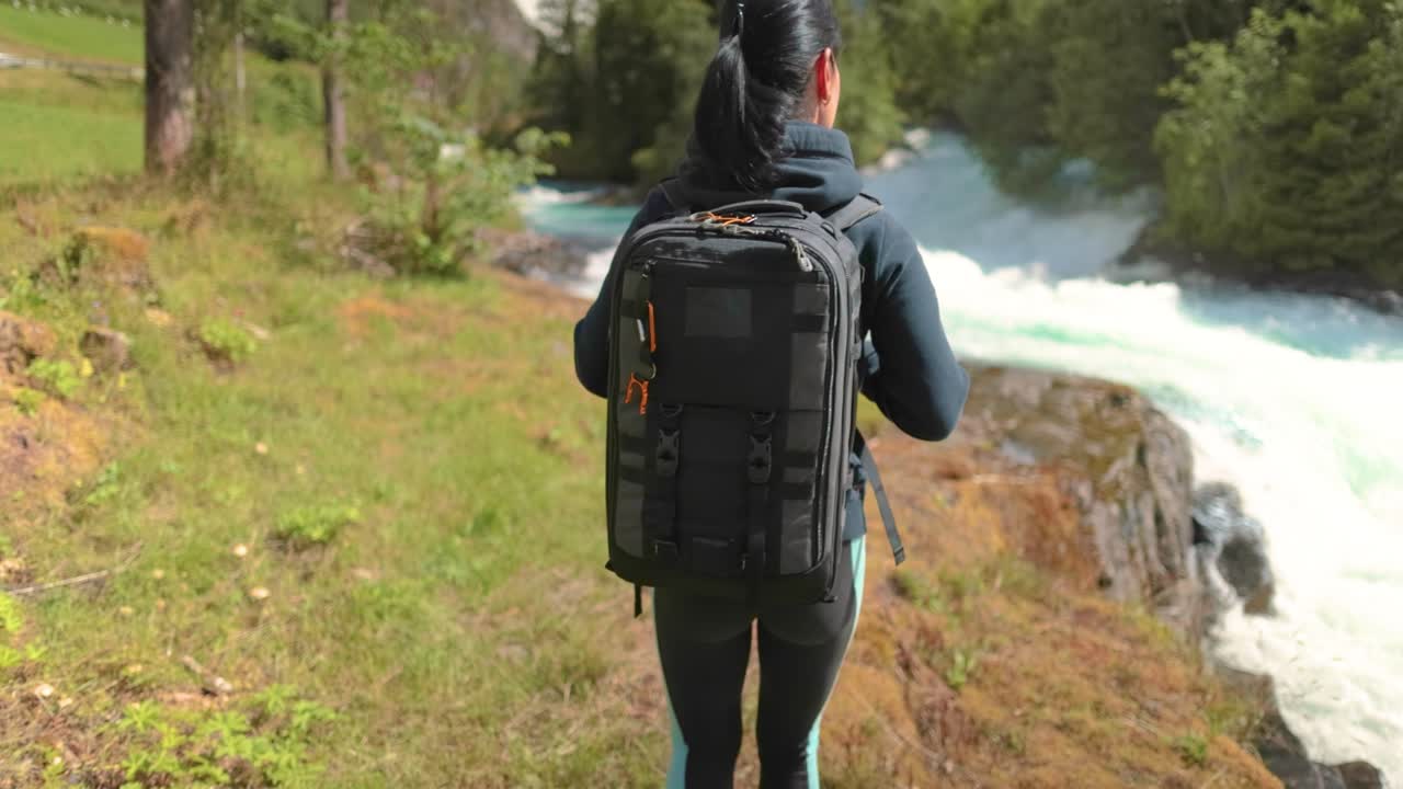 una mujer de senderismo camina con una mochila de senderismo en la hermosa naturaleza de noruega.