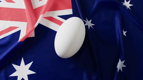 white rugby ball over flag of australia with copy space, in slow motion