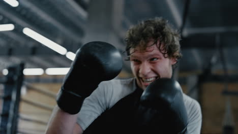 Agitated-sportsman-doing-hits-at-gym.-Fighter-kicking-punching-bag-in-sport-club