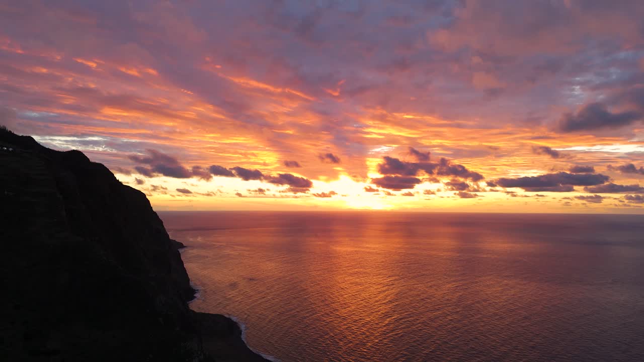 Aerial journey across Ponta da Ladeira cliffs of Madeira, idyllic coastline stretching into the horizon with rays of golden hour light