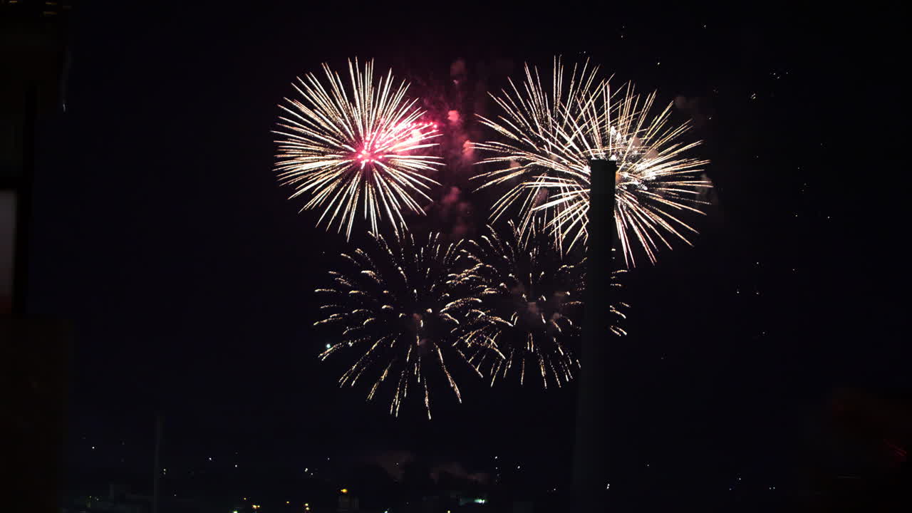 hermosos fuegos artificiales explotando en el cielo nocturno sobre la ciudad