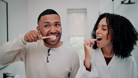 couple brushing teeth together in the bathroom