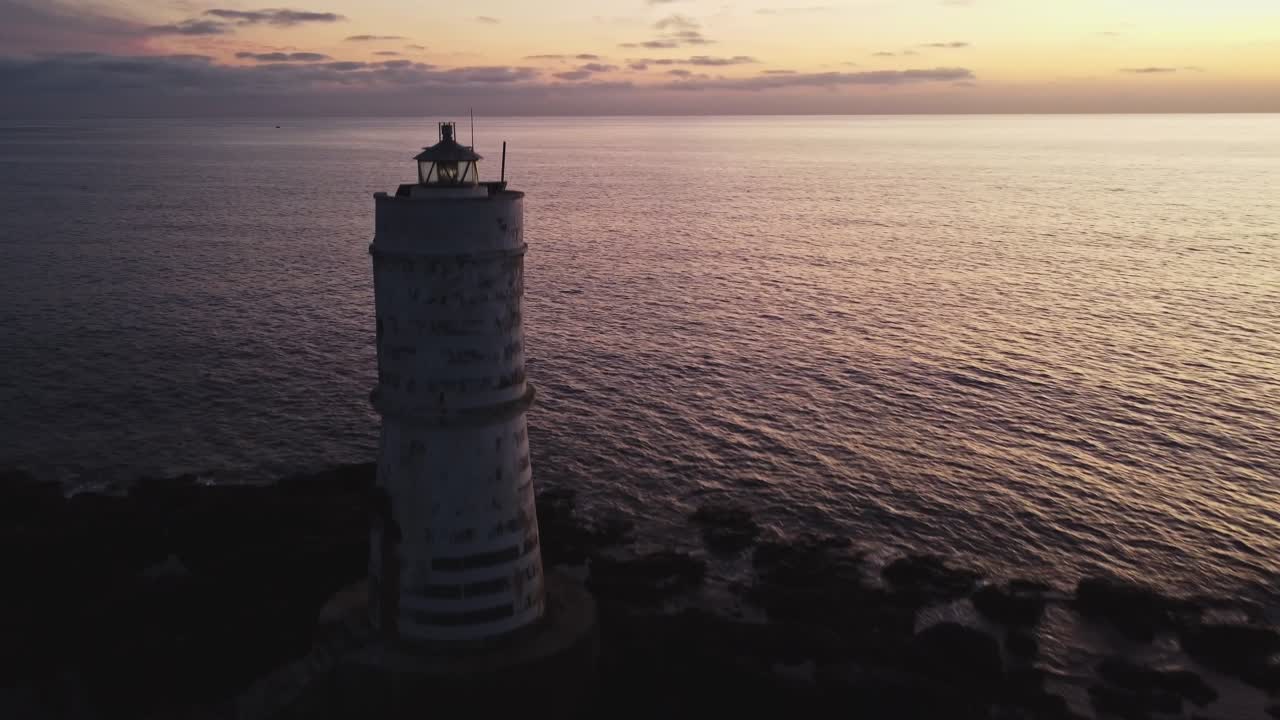 primer plano aéreo del faro de calasetta, conocido como mangia barche, círculo pan, anochecer