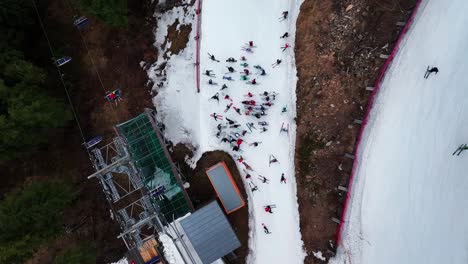 aerial top down view of skiers gather near dolni morava chairlift terminal