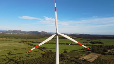 green energy wind turbine spinning in sardinia countryside landscape, blue sky