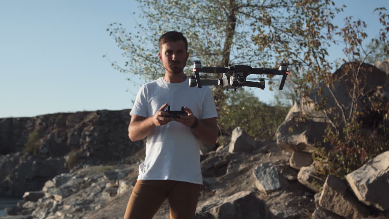 Man flying a drone over a quarry landscape