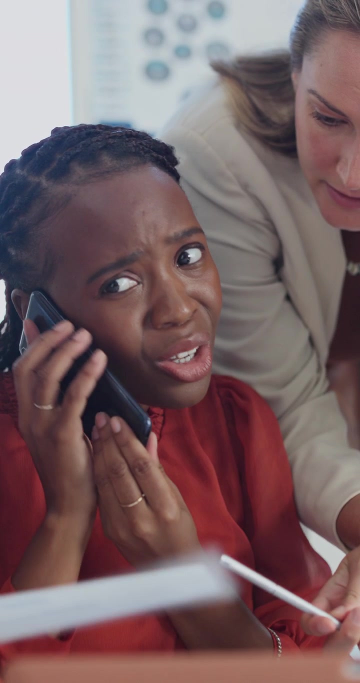 Stressed Businesswoman Talking on Phone During Office Meeting