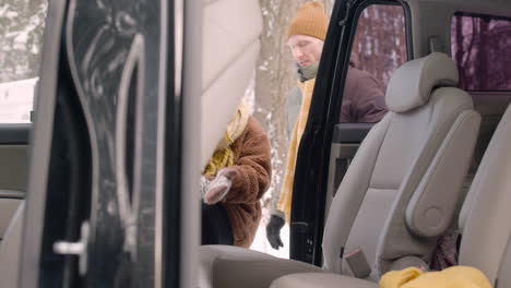 side view of a girl sitting in the back seat of a car