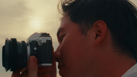 man taking a photo at sunset