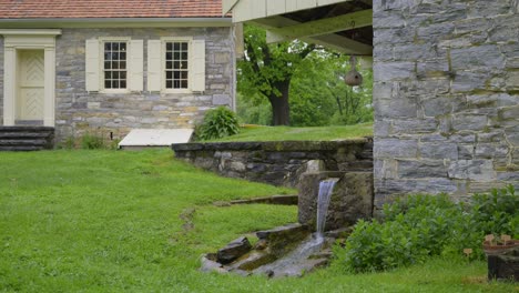 small stream of water flowing in the yard of a colonial looking home