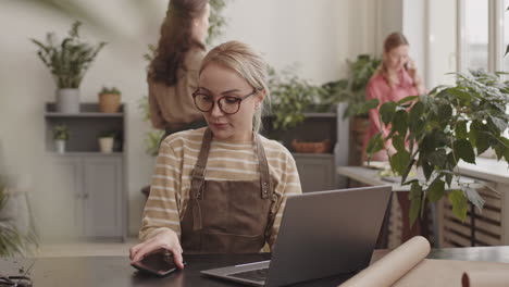 florist working on laptop and smartphone