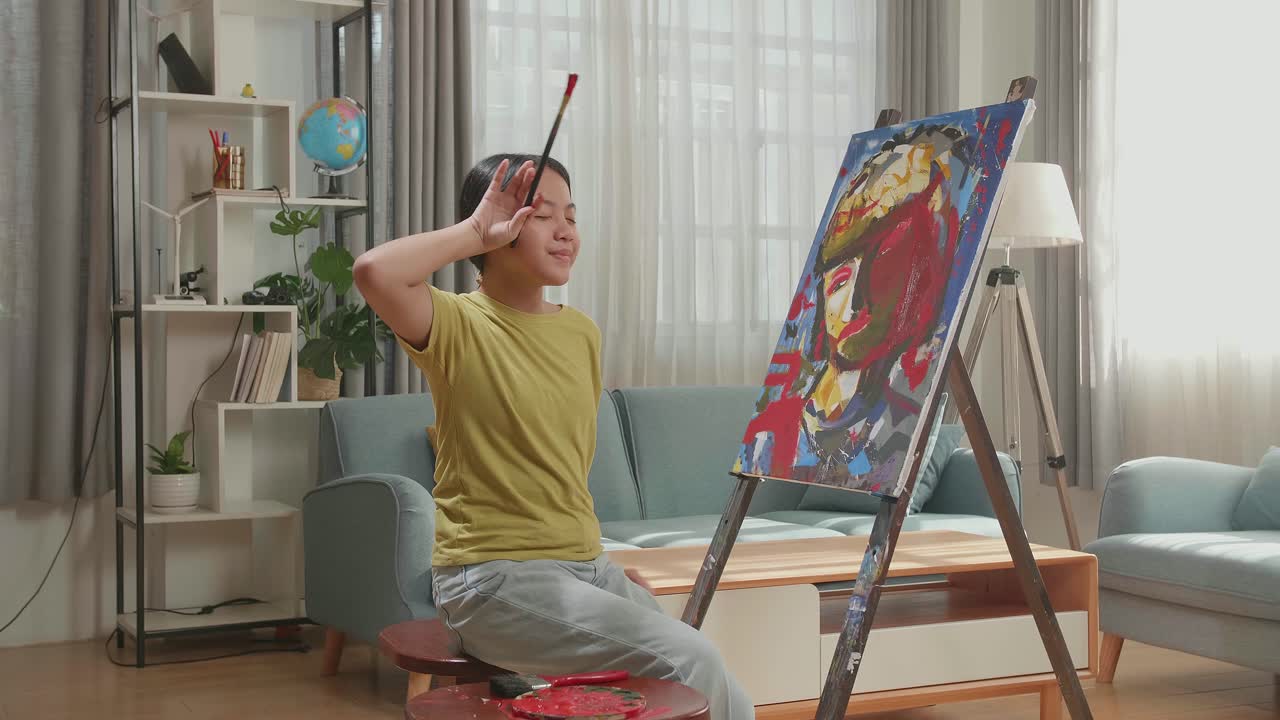 Asian Artist Girl Holding Paintbrush Wipe The Sweat Before Crossing His Arms And Smiling After Finish Painting On The Canvas