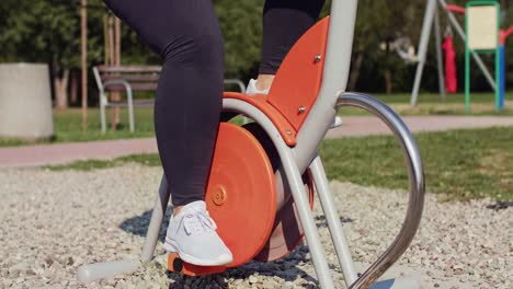 Mujer-Utilizando-Bicicleta-Estática-En-El-Parque-Público/rzeszow/polan