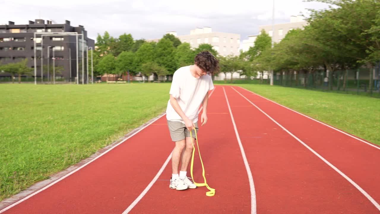 Man Exercising with Resistance Band on Track