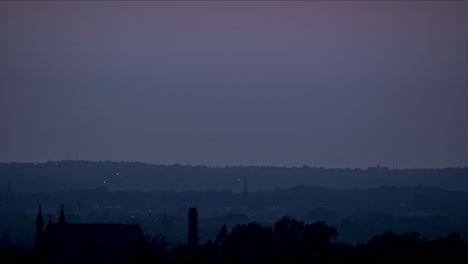 misty yellow day turning blue as sun sets leading into night, shot above a small part of manchester
