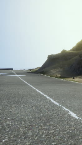 empty road leading uphill towards a mountain