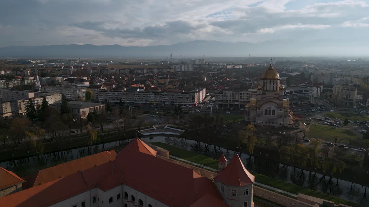 vuelo aéreo ascendente con drones alrededor del castillo cetatea făgărașului y la iglesia ortodoxa catedrala sfântul ioan botezătorul de făgăraș en românia - vista de pájaro de fagaras en rumania en invierno de 2022